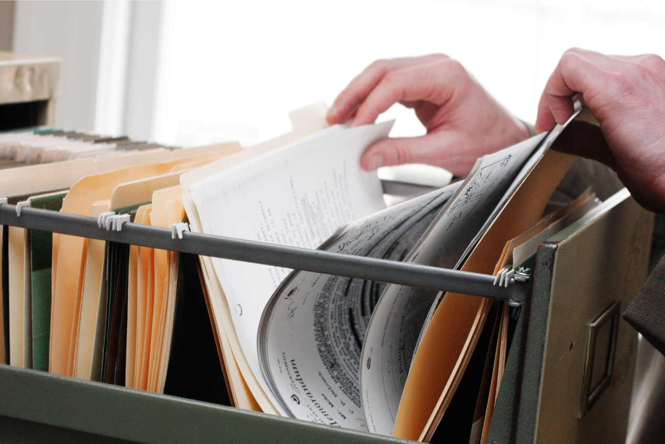 hands thumbing through folders in a file cabinet