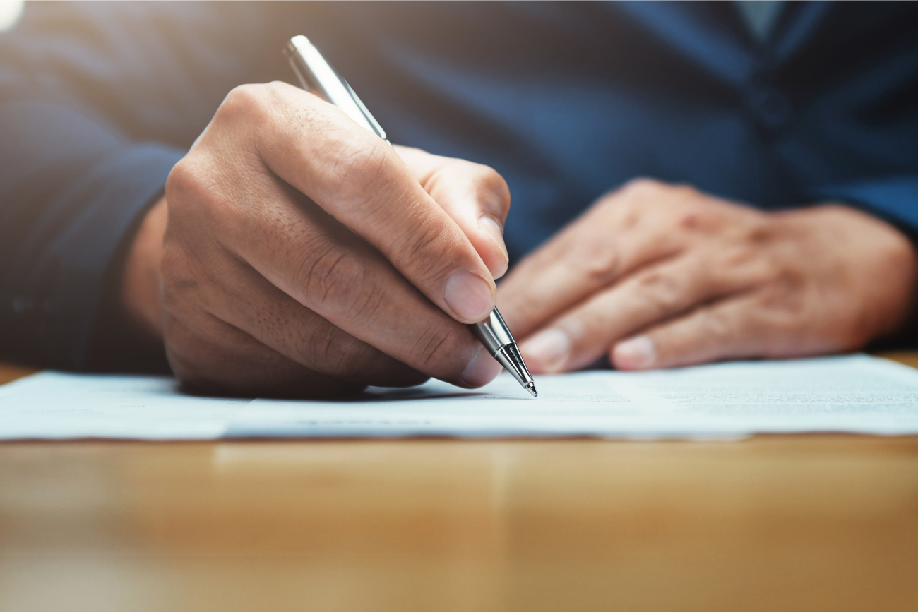 hand with pen signing document