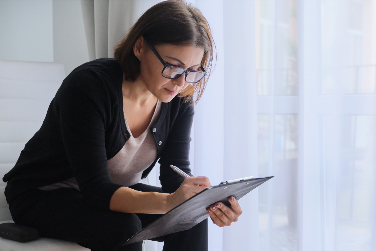 woman looking at documents on clipboard