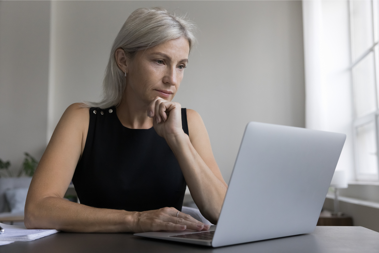 woman looking at laptop on desk at home